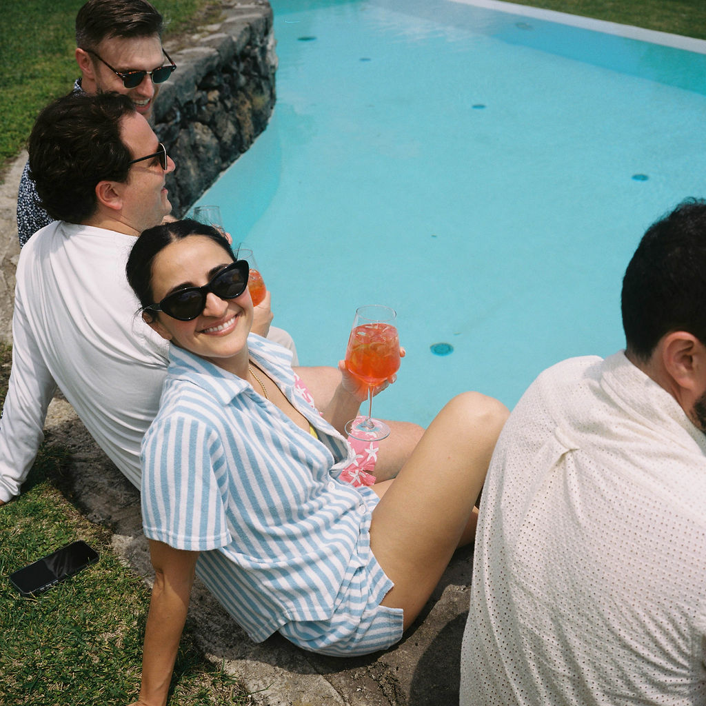 Bride lounges by pool at Sicily destination wedding featuring a multi-day guest experience. 