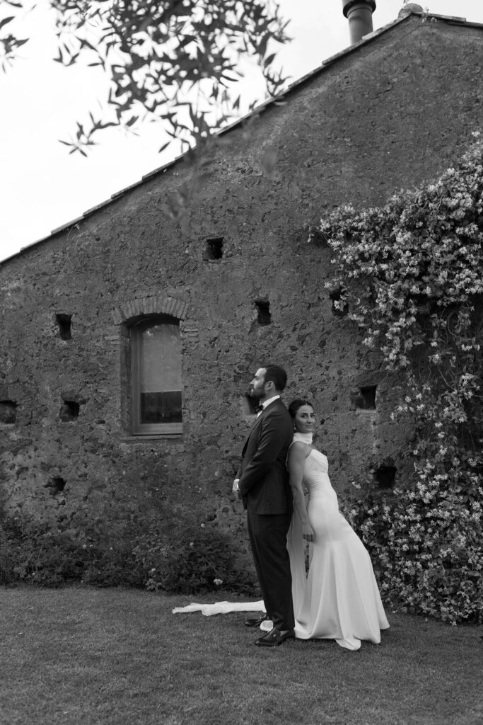 Sicily Italy destinations offering scenic backdrops for weddings as bride and groom pose in front of stone architecture. 