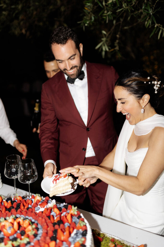 Couple cutting cake during their Monaci delle Terre Nere wedding reception. 