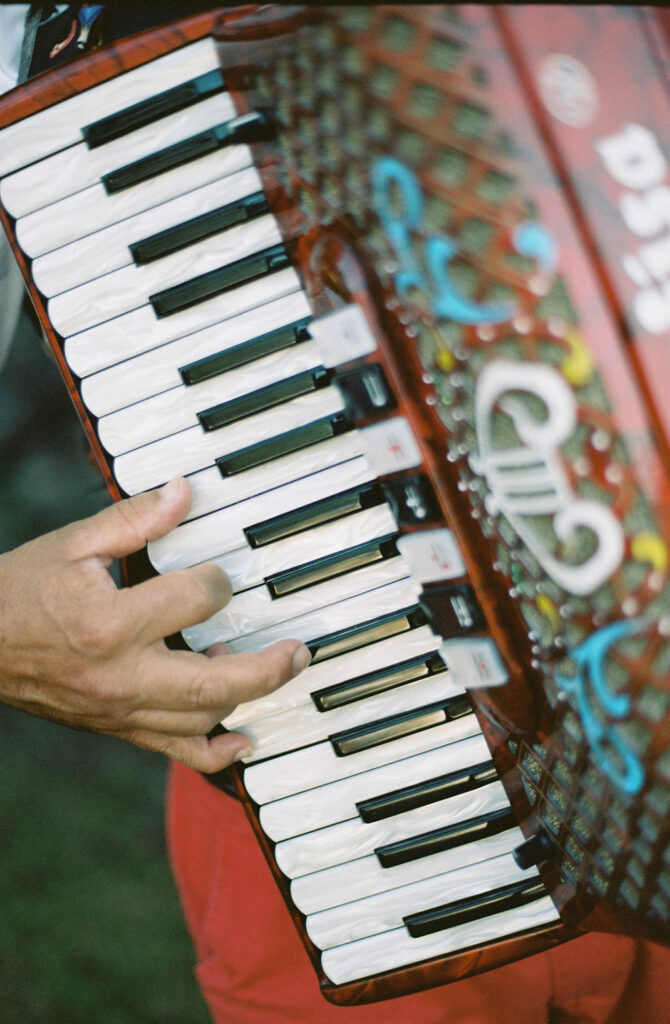 Man plays accordion at ​Sicily, Italy wedding.  