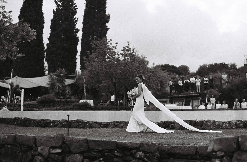 Bride walks done the aisle at a venue in Sicily, Italy perfect for elegant destination celebrations. 